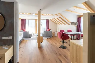 a living room with red chairs and a table at Apartments by Bemelmans-Post in Collalbo