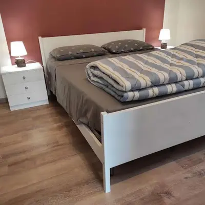 a bedroom with a white bed and a white night stand at Da Carla Dolomiti Val di Zoldo in Val di Zoldo