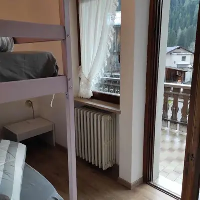a bedroom with a bunk bed and a window at Da Carla Dolomiti Val di Zoldo in Val di Zoldo