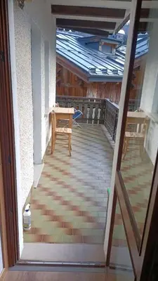 an outside view of a porch with a table and chairs at Da Carla Dolomiti Val di Zoldo in Val di Zoldo