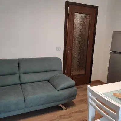 a living room with a green couch and a door at Da Carla Dolomiti Val di Zoldo in Val di Zoldo