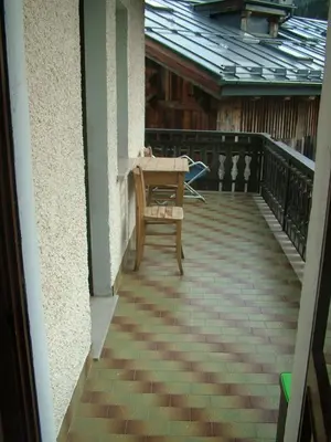 a patio with a table and a bench on a balcony at Da Carla Dolomiti Val di Zoldo in Val di Zoldo