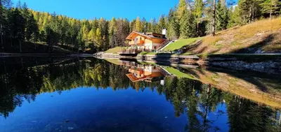 a house sitting on the side of a lake at Rifugio Lago D'Ajal in Col