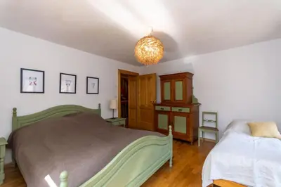 a bedroom with a bed and a chandelier at Casa Narciso in Rocca Pietore