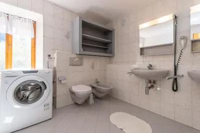 a bathroom with a washing machine and a sink at Casa Narciso in Rocca Pietore