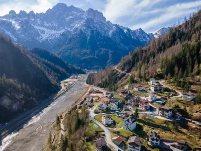 an aerial view of a village next to a river and mountains at Casa Narciso in Rocca Pietore