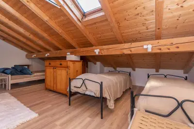 two beds in a room with wooden ceilings at Casa Narciso in Rocca Pietore