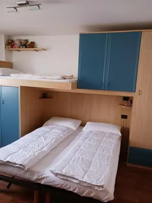 a bed in a room with blue cabinets at Rosa e Margherita in Brez