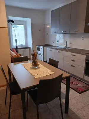 a kitchen with a wooden table with chairs and a table and a table at Rosa e Margherita in Brez