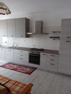 a kitchen with white cabinets and a stove top oven at Rosa e Margherita in Brez