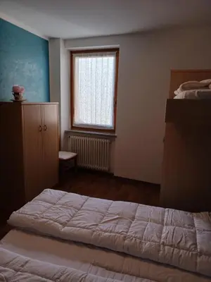 a bedroom with a large bed and a window at Rosa e Margherita in Brez