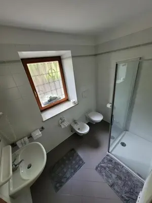 a bathroom with two sinks and a shower and a window at Appartements Lena in Merano