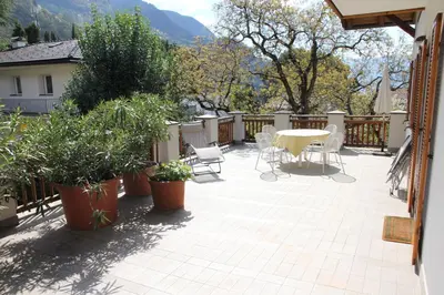 a patio with a table and chairs and plants at Appartements Lena in Merano