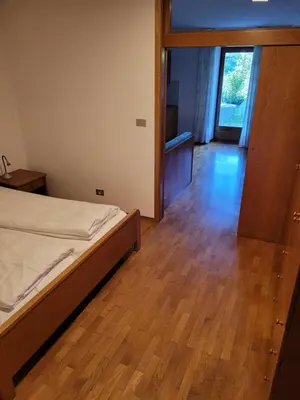 a bedroom with a bed and a wooden floor at Appartements Lena in Merano