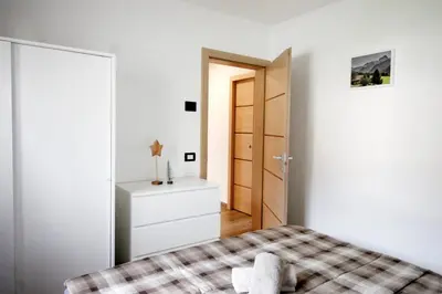 a bedroom with a bed and a dresser and a door at CASA YARA - 3 camere, 2 bagni, parcheggio Dolomiti Affitti in Cavalese