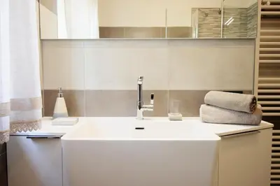 a bathroom with a white sink and a mirror at CASA YARA - 3 camere, 2 bagni, parcheggio Dolomiti Affitti in Cavalese
