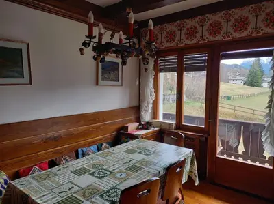 a dining room with a table and a window at Appartamento a San Vito di Cadore in San Vito di Cadore