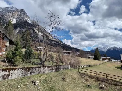 a field with a fence in front of a mountain at Appartamento a San Vito di Cadore in San Vito di Cadore