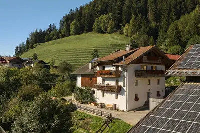 a house with solar panels in front of a hill at Pfitscherhof in Campo di Trens