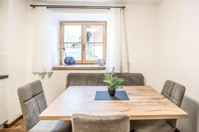 a dining room with a wooden table and chairs at Pfitscherhof in Campo di Trens