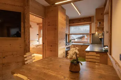 a kitchen with wooden walls and a wooden table at Casa Ca dei Pini in Cortina dʼAmpezzo