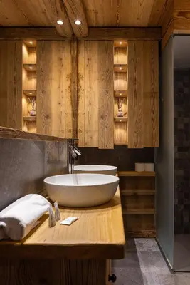 a bathroom with a white sink on a wooden counter at Casa Ca dei Pini in Cortina dʼAmpezzo