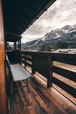 a bench on a porch with a view of mountains at Casa Ca dei Pini in Cortina dʼAmpezzo