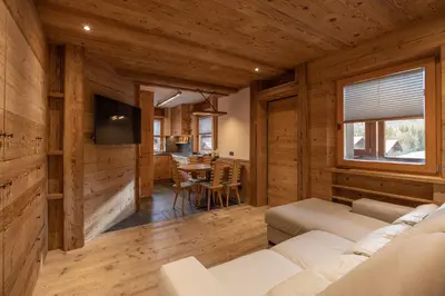 a living room with a white couch and a table at Casa Ca dei Pini in Cortina dʼAmpezzo