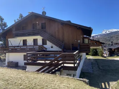 a building with wooden stairs in front of it at Casa Ca dei Pini in Cortina dʼAmpezzo