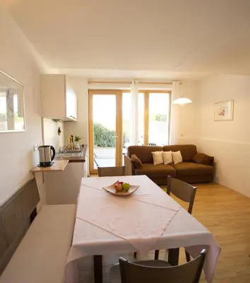 a kitchen and a living room with a table and chairs at Panorama Residence Schlossblick - Apartments Erdgeschoss in Rodengo