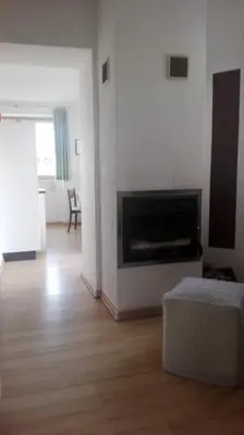 a living room with a fireplace and a room with a table at Panorama Residence Schlossblick - Apartments Erdgeschoss in Rodengo