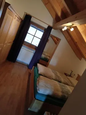 an attic room with a green couch and a window at Waldnerhof in Soprabolzano