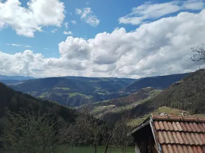 a view of a valley in the mountains with a building at Waldnerhof in Soprabolzano