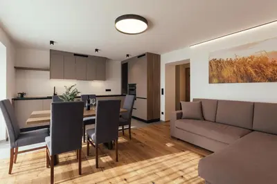 a living room and dining room with a couch and a table at Alpenglow Apartments in Collalbo